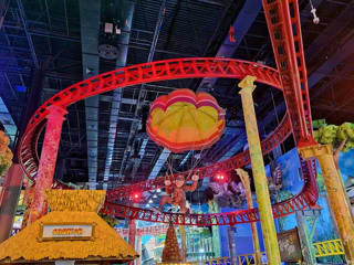The red Forest Train track crosses Adventureland’s colourful jungle scenery.