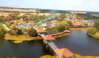 Panorama elevado do Adventure Park Geelong, do passadiço junto ao lago às torres dos escorregas.
