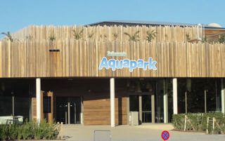 Entrada exterior do Bellewaerde Aquapark sob a placa colorida.