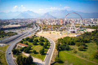 Vue générale at Aktur Park: the park’s tall silhouettes stand before Antalya’s mountains.
