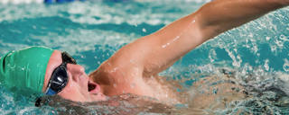 Um nadador percorre uma das pistas marcadas da piscina desportiva.