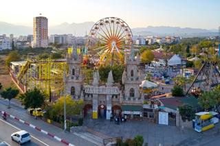 Wide view of Aktur Park with the entrance, Twister Coaster and the classic Ferris wheel.