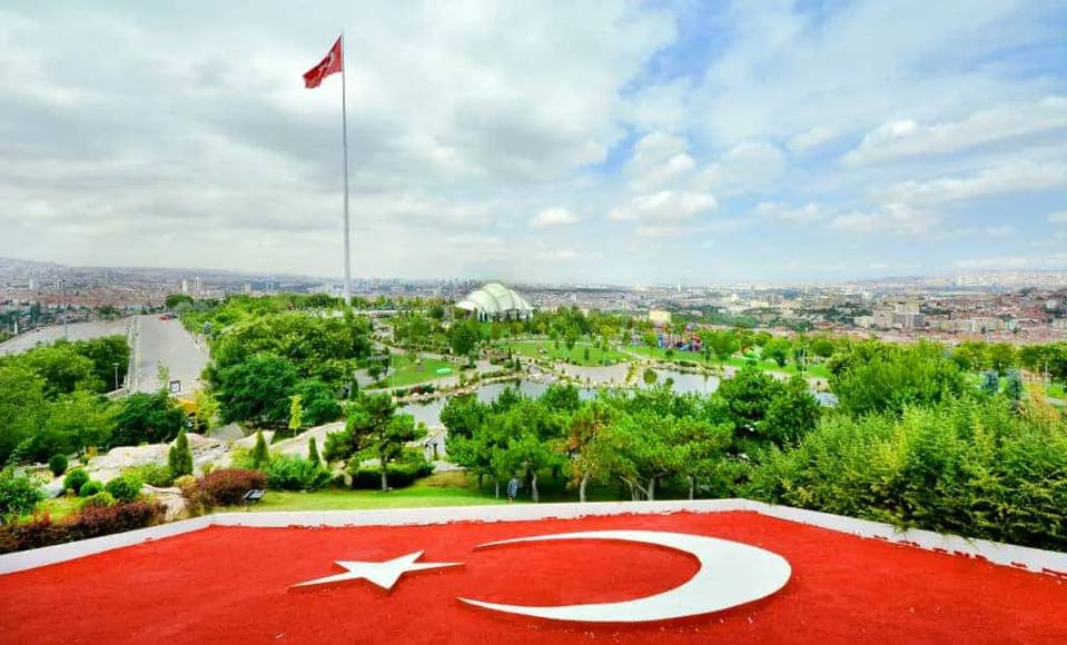 Panoramisch uitzicht over 50. Yıl Parkı met de Turkse vlag, vijvers en Ankara beneden.