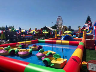 Colourful paddle boats with the Ferris wheel and inflatables behind
