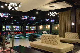 Wide view of glowing lanes and lounge sofas in the Hurst bowling centre.