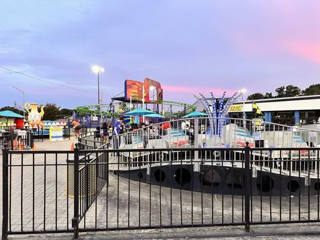 Wide view of the outdoor playland with Rattler and the small rides.