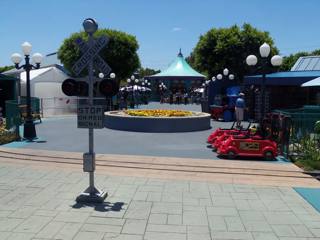 Praça central do Adventure City em 2012, entre a passagem do comboio em miniatura, flores, lojas e carrossel.