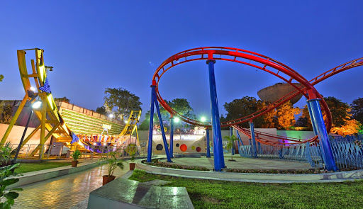 Panorama nocturno de Amrapali FunLand, con la vía roja y Tall Tower sobre los paseos iluminados.