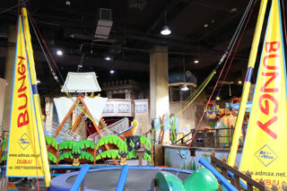 The Bungy Jump trampolines open a view toward the pirate ship and neighbouring rides.