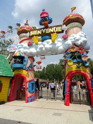 Le portail de bienvenue coloré de Parc Saint Paul, avec la grande roue au second plan