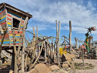 Casitas y pasarelas de juego de madera en bruto bajo el cielo azul en uno de los minimundos de ArkaZien.