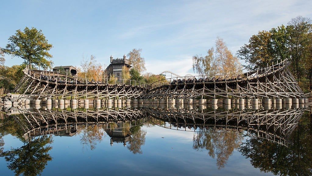 The wooden silhouette of Joris en de Draak runs beside the lake and is reflected in the still water.