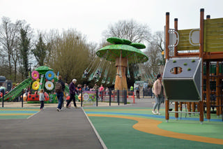 General view of Cita-Parc from the playground, with colourful rides beneath the trees.