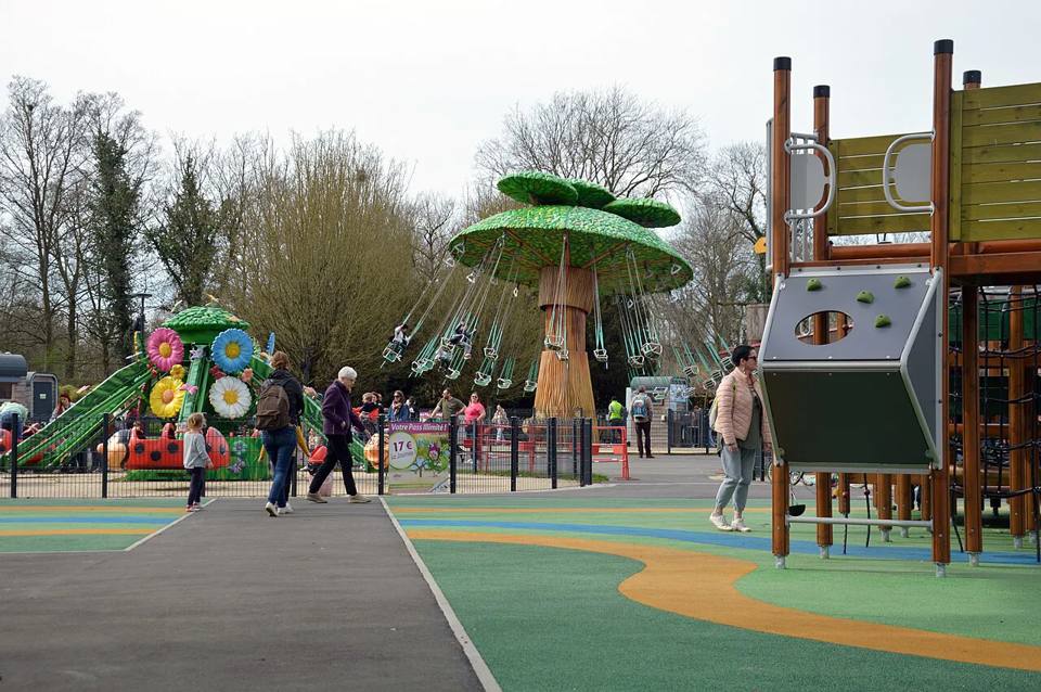 General view of Cita-Parc from the playground, with colourful rides beneath the trees.