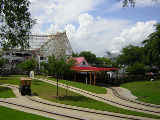 Pista de automóveis antigos no AstroWorld com Texas Cyclone e o Astrodome ao fundo
