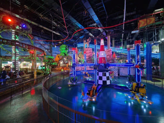Adventureland’s illuminated indoor landscape around Air Race and the overhead tracks.