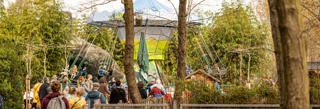 O amplo parque infantil do Familiepark Harry Malter estende-se entre árvores e estruturas cobertas.