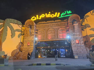 Illuminated stone entrance of Adventure World Dammam