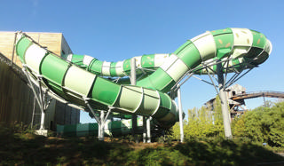 Grandes escorregas verdes do Bellewaerde Aquapark vistos do exterior.