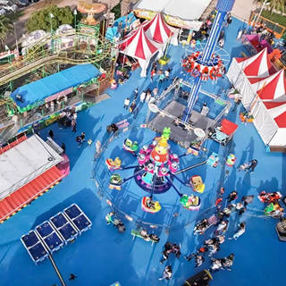 Daytime aerial view of Funnyland rides, including Crazy Chenille, Les Soucoupes and Funny Tower.