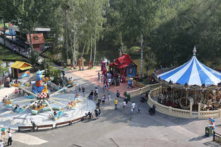Vue d’ensemble des allées arborées, du carrousel et des attractions familiales de Parc Saint Paul