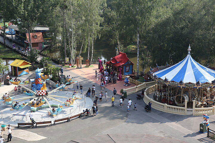 Vue d’ensemble des allées arborées, du carrousel et des attractions familiales de Parc Saint Paul