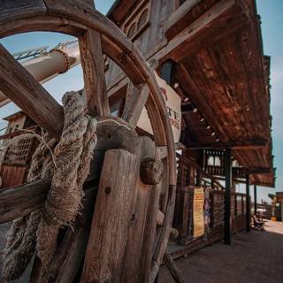 A timber wheel before the western buildings of Astoria Village