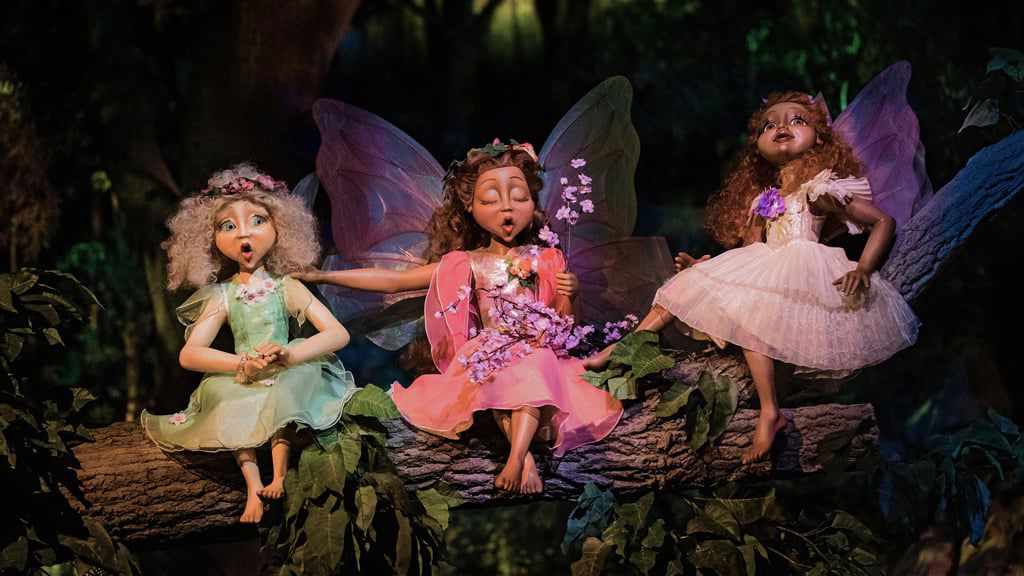 Three fairies sing on a flowering branch in Droomvlucht’s wondrous forest.