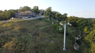 Vista aérea do Aerie’s Resort & Winery: a encosta arborizada, os edifícios e o teleférico dominam o Mississippi.