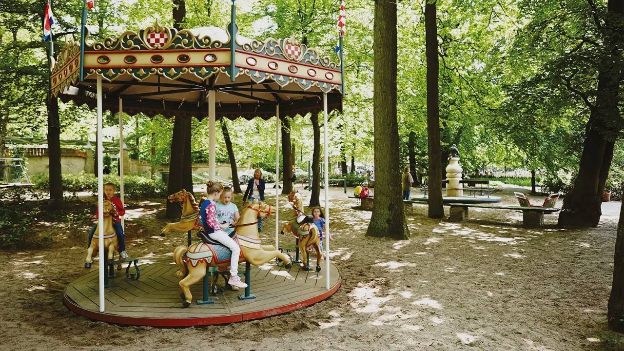 Children ride the small historic roundabout at Kindervreugd.