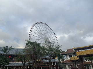 A Sun Wheel sobre telhados de telha e pavilhões asiáticos no interior do parque.