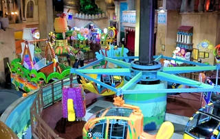 Overview of Antic’s Land with suspended rides, the pirate ship and monorail among the scenery.