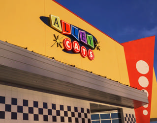 Main frontage and entrance of Alley Cats Hurst beneath a blue sky.
